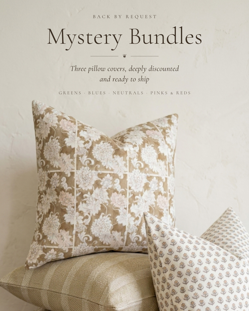 Three decorative throw pillows in neutral tones stacked on a rustic wooden shelf against a textured off-white wall. Text at the top reads 'Mystery Bundles' with smaller descriptive copy.